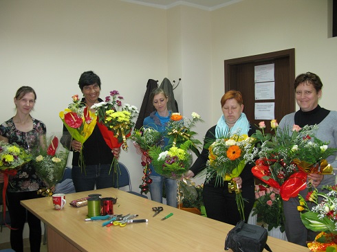 Uczestnicy projektu w czasie kursu florystycznego ze swoimi pracami.