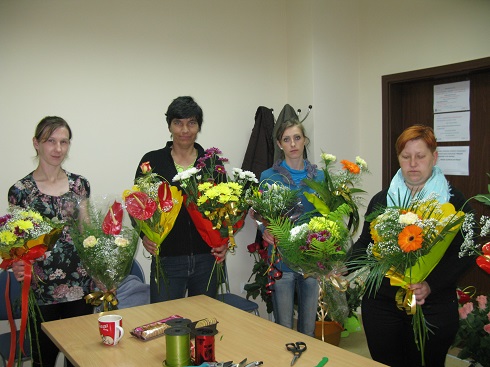 Uczestnicy projektu w czasie kursu florystycznego ze swoimi pracami.
